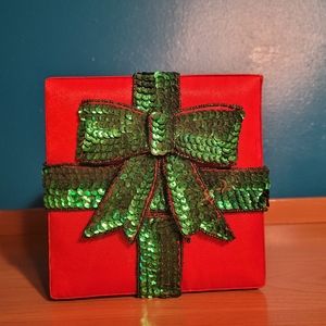 Red satin box with green sequin ribbon and bow.